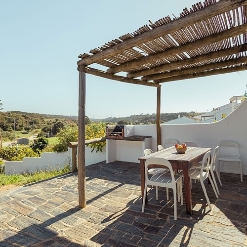 una mesa y sillas en un patio con un techo de madera