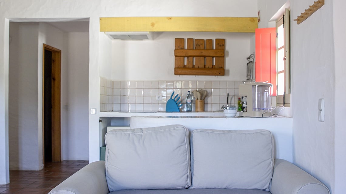 Couch com vista para a cozinha rústica da Aldeia da Pedralva.