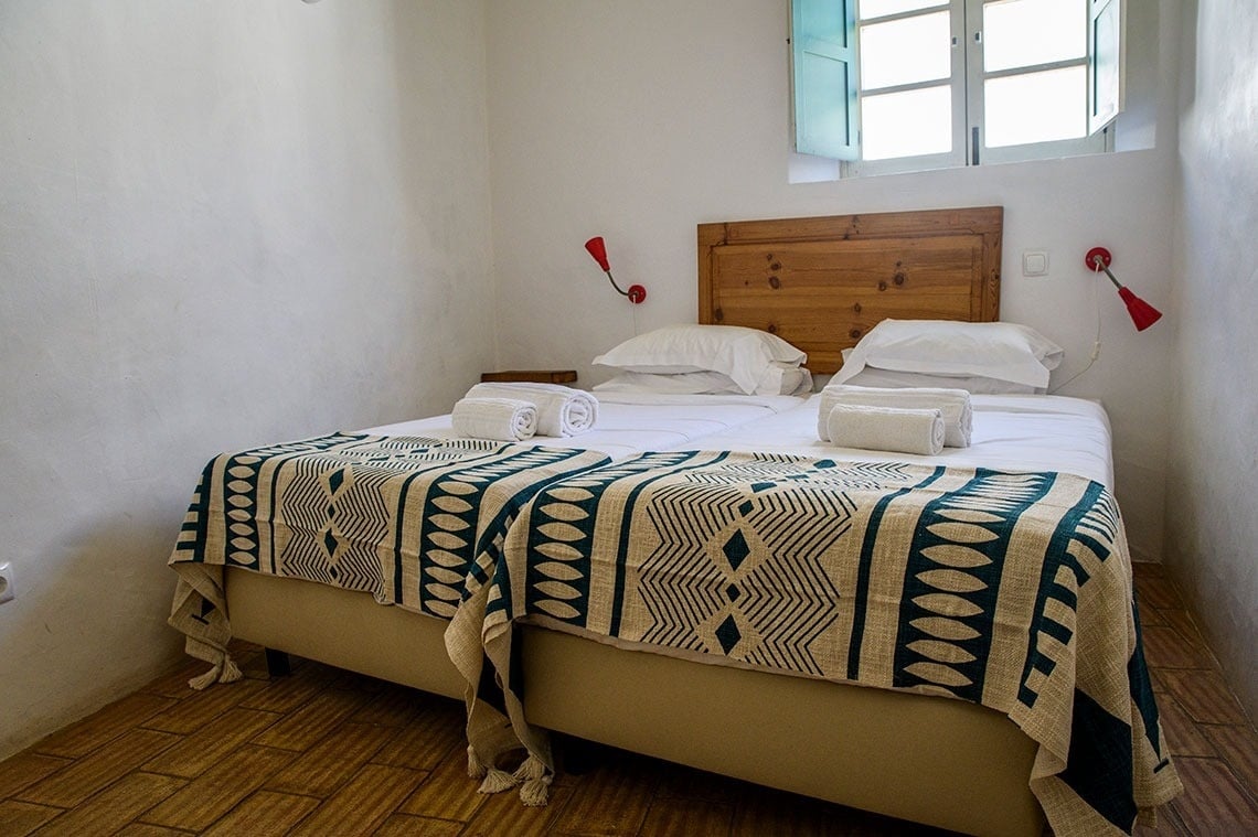 una habitación con dos camas y una ventana