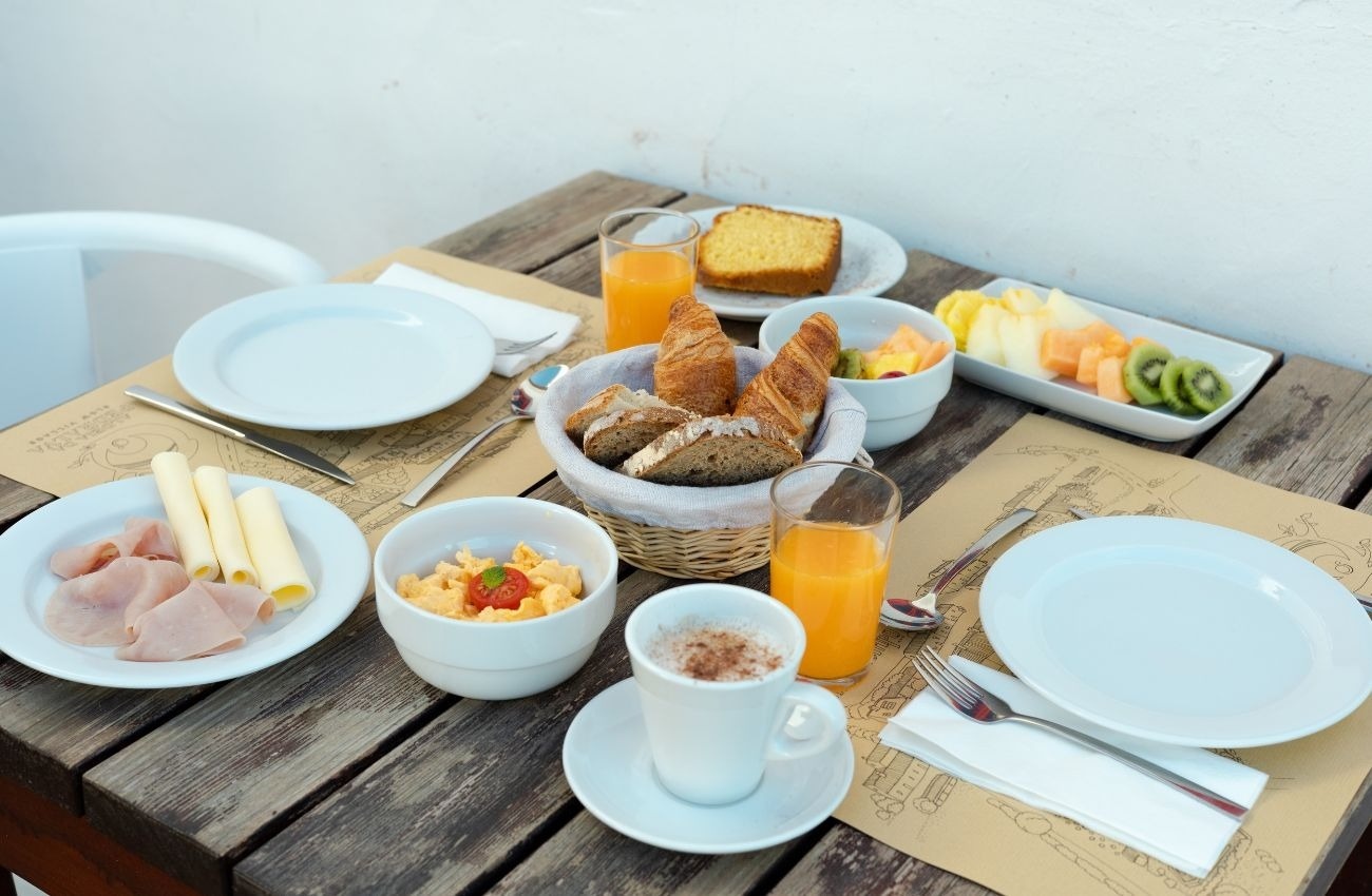 a wooden table topped with a variety of food including croissants