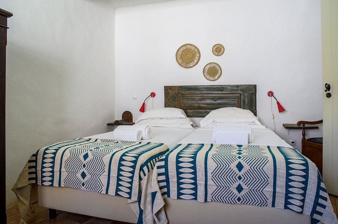 una cama con una manta azul y blanca encima