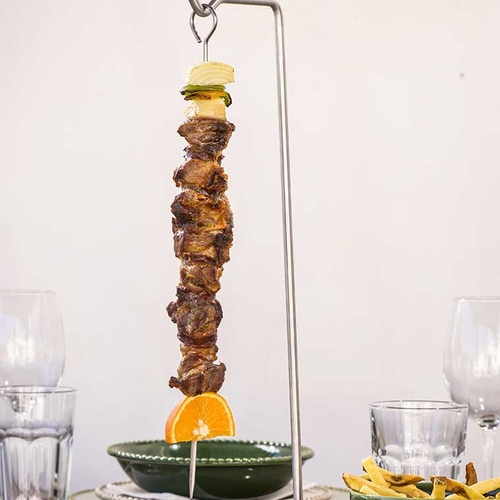 Authentic Aldeia da Pedralva traditional meal featuring a hanging meat skewer with orange and fries.