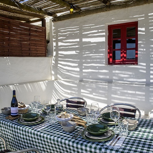 a bottle of wine sits on a table with plates and glasses