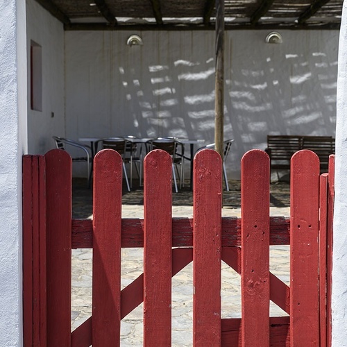 a red fence is in front of a white building
