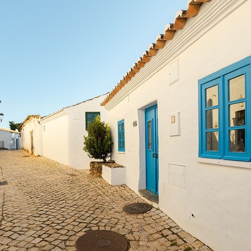 un edificio blanco con una puerta azul y una ventana