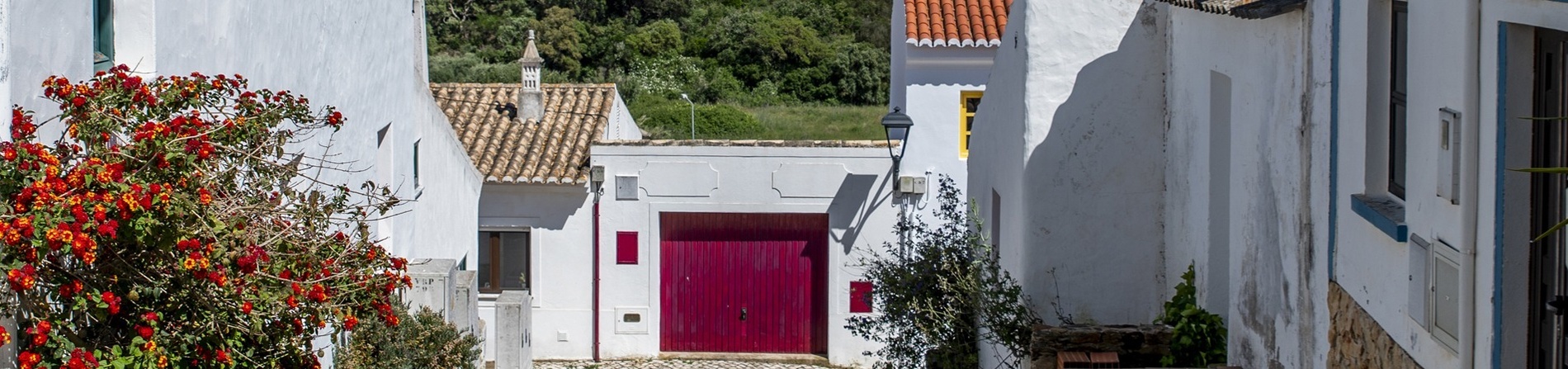 a white building with a red door and a yellow window