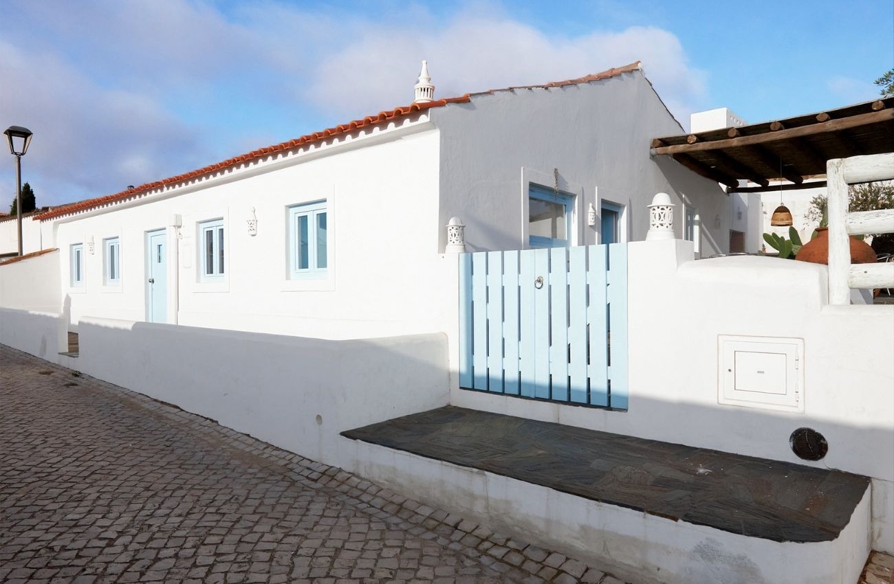 uma casa branca com janelas azuis e uma cerca azul