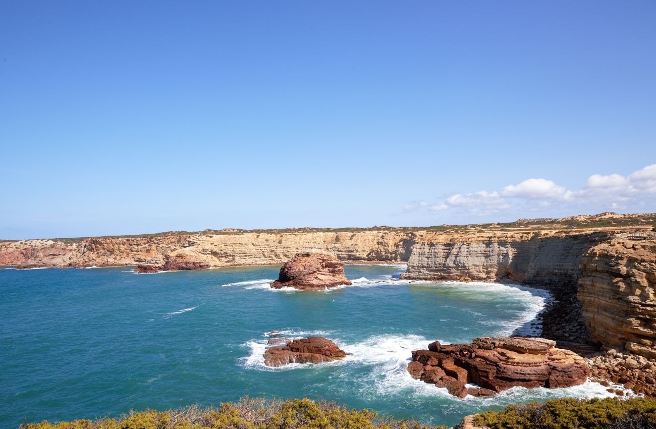 una playa con un acantilado en el fondo