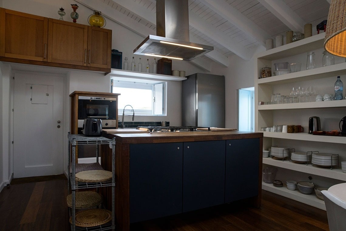 una cocina con gabinetes azules y estantes blancos