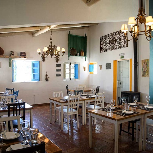 Charming dining room at Aldeia da Pedralva with rustic tables and chairs.