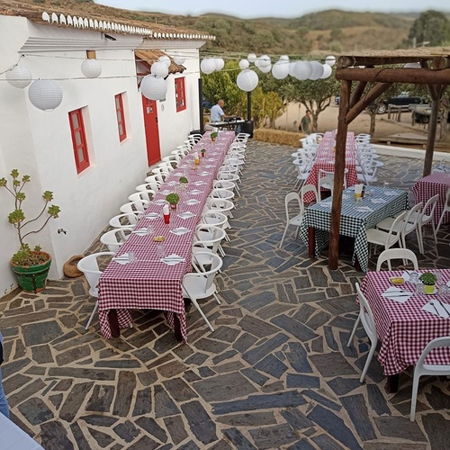 una larga mesa con una manta a cuadros roja y blanca