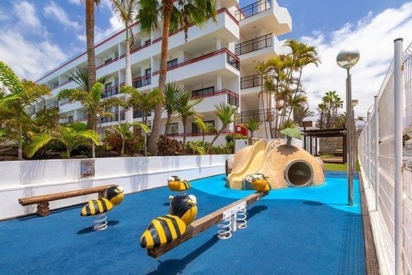 Resort Alexandre Corporativa: divertido parque infantil con palmeras, tobogán y balancines.