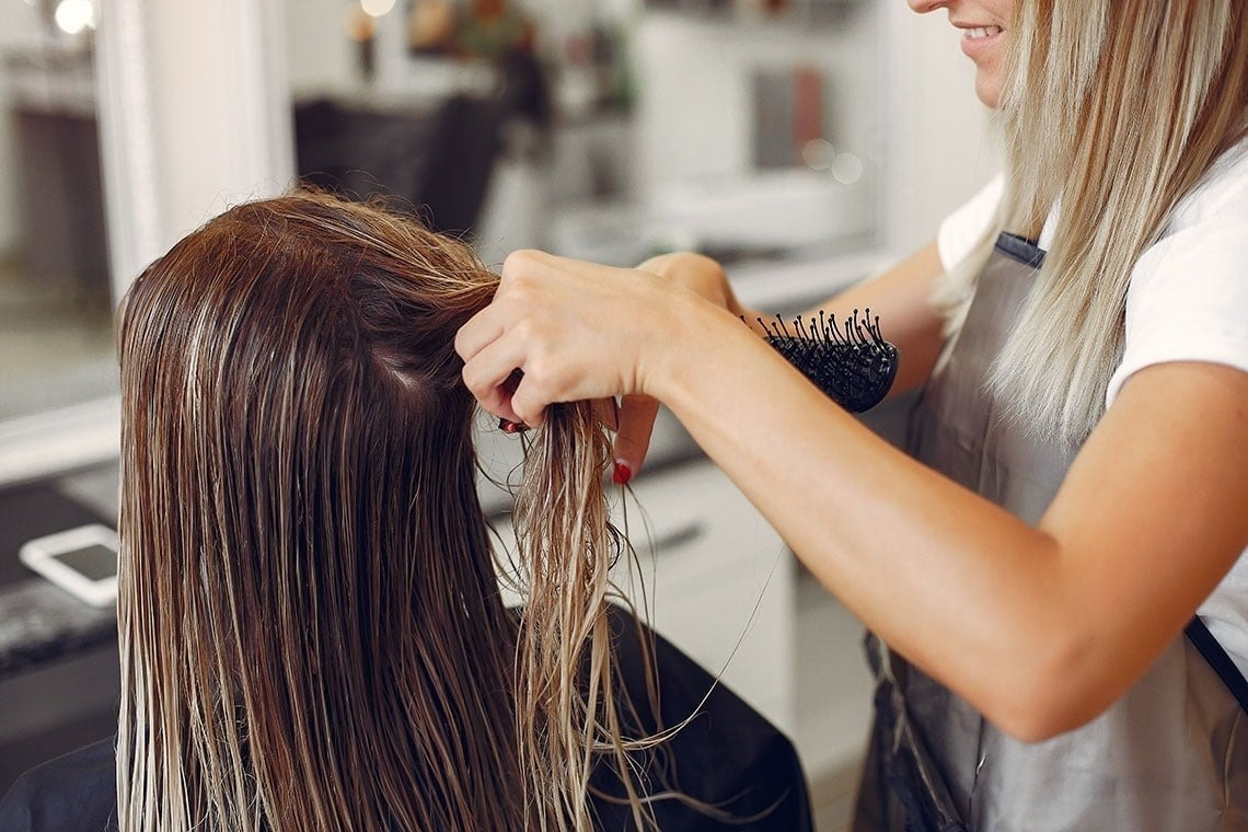 Friseurservice im Hotel Alexandre Corporativa: Stylistin kämmt nasse Haare einer Kundin.