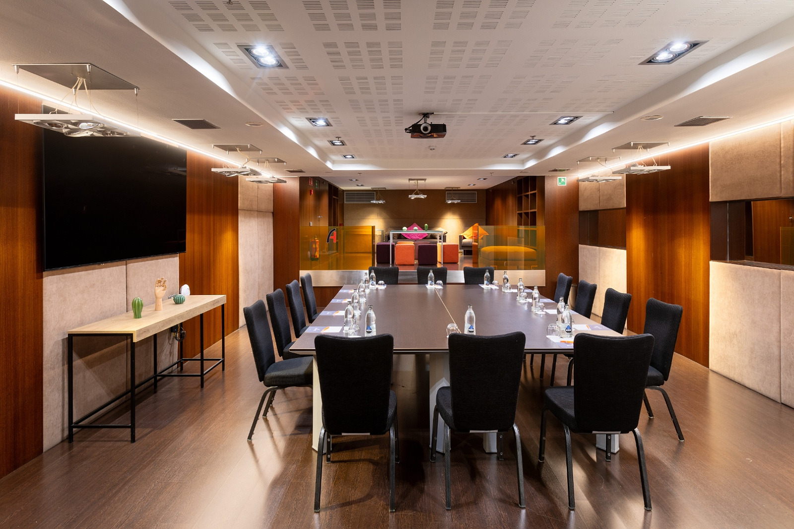 Salle de réunion Alexandre Corporativa moderne et lumineuse avec grande table ovale et écran.