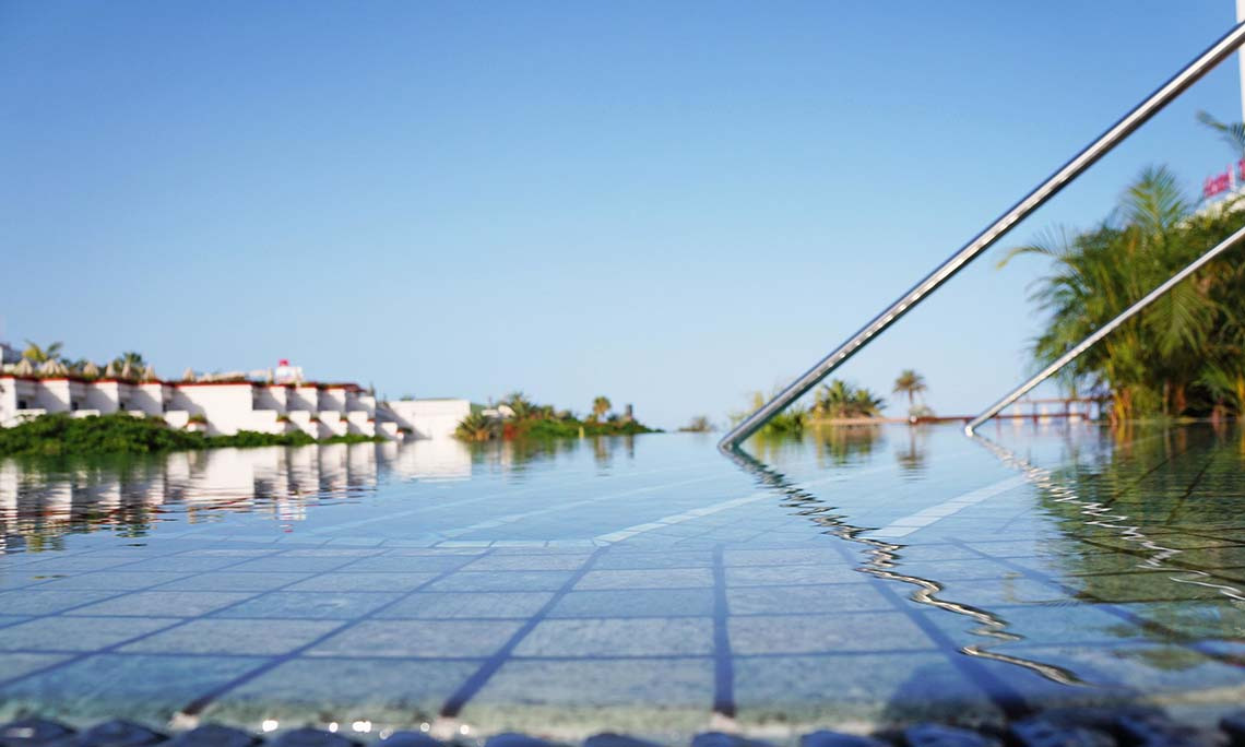 Infinity-Pool mit Blick auf Alexandre Corporativa Hotel und Palmen.