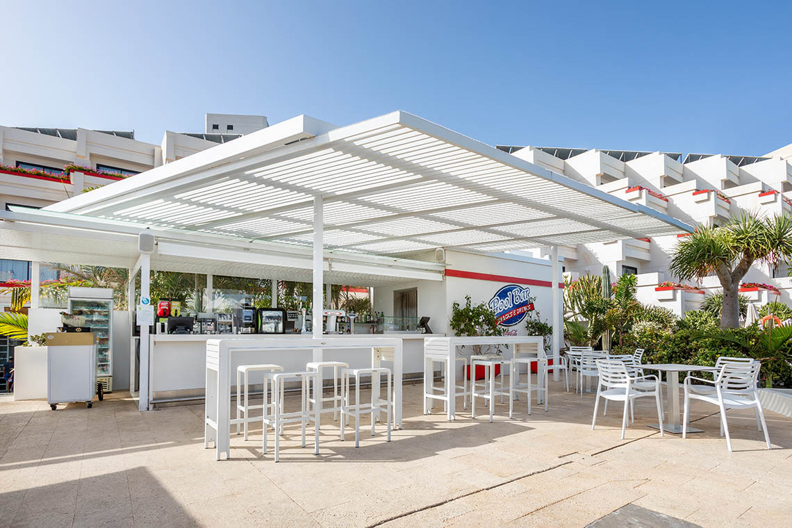 Luxuriöse Hotelterrasse mit Meerblick, moderner Lounge, Palmen und Kakteen – ideal für Alexandre Corporativa.