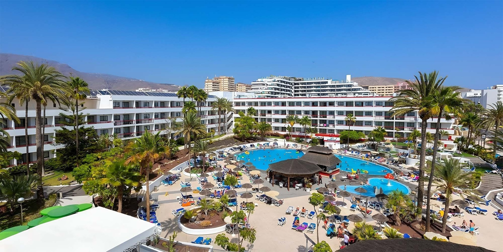 Alexandre La Siesta Teneriffa: Weitblick auf Hotelanlage, Poolbereich mit Palmen und Berge. Top Services für Gäste.