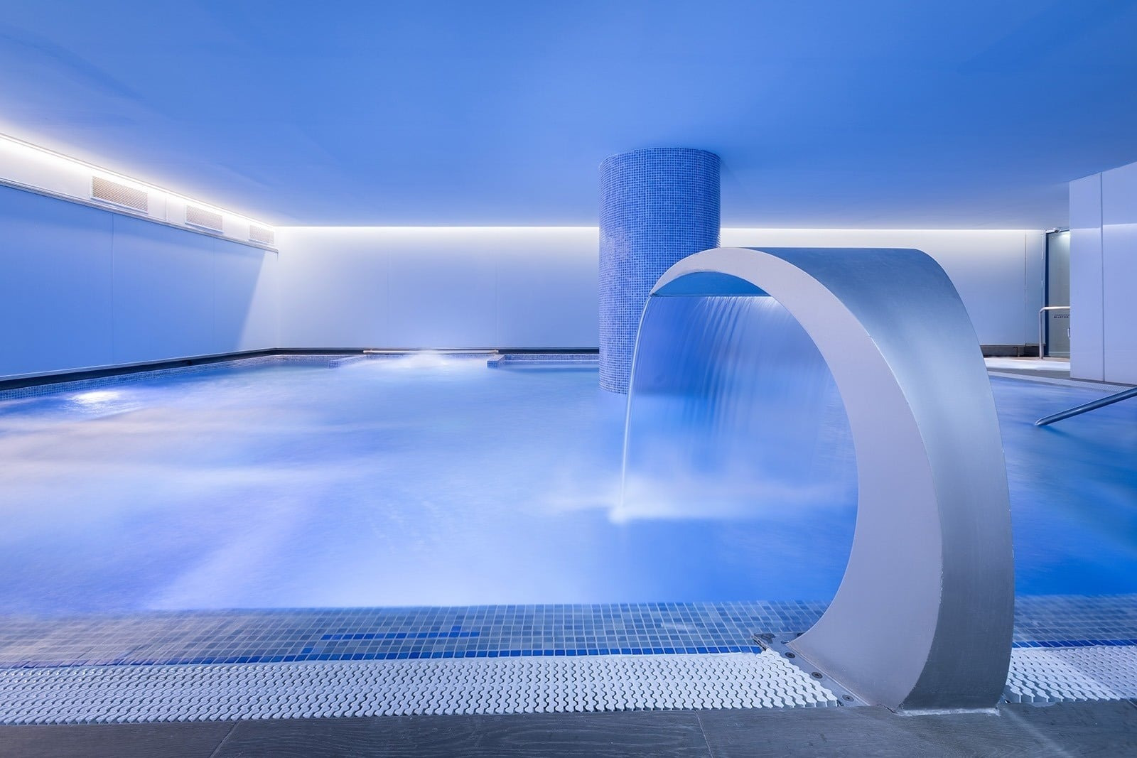 Alexandre Corporativa: Moderner Spa mit Whirlpool, blauen Mosaikliegen und Blick auf die grüne Terrasse.