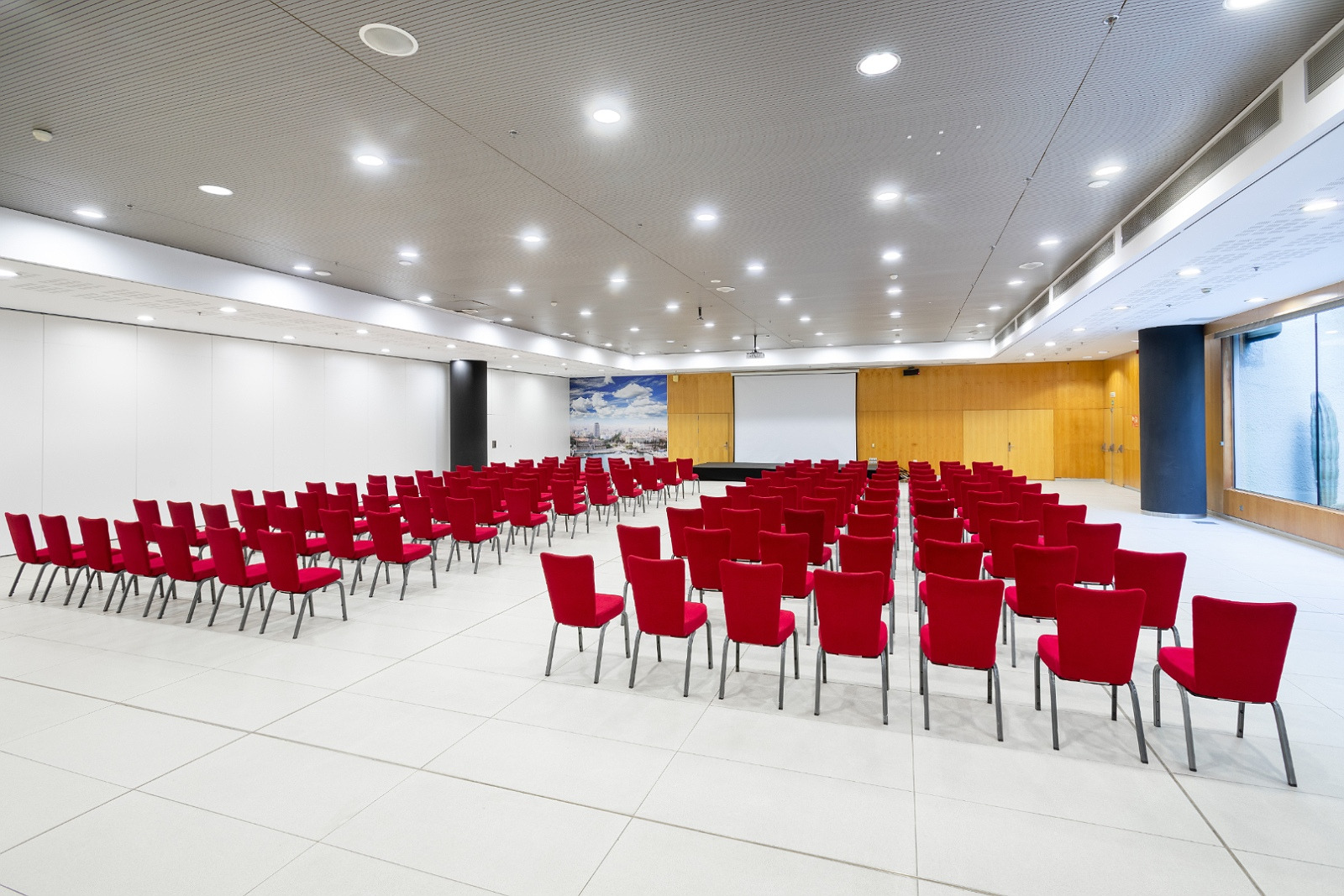 Salle de conférence Alexandre Corporativa avec sièges rouges pour événements.