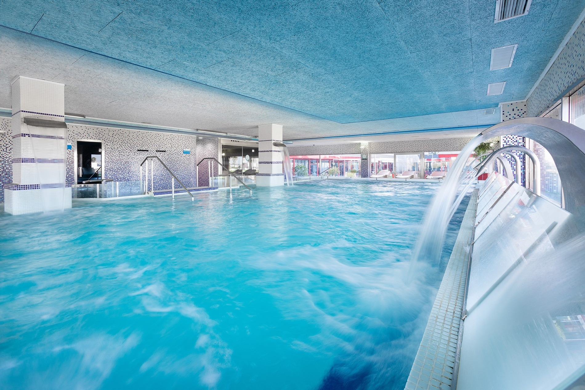 Natürliches Spa im Alexandre FrontAir Congress: Entspannender Innenpool mit Wasserfällen und Mosaikfliesen.