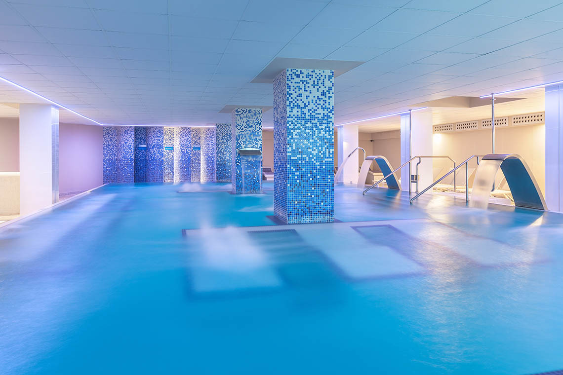 Piscina climatizada de Alexandre Corporativa con cascada y diseño moderno. Ideal para relajación y bienestar.