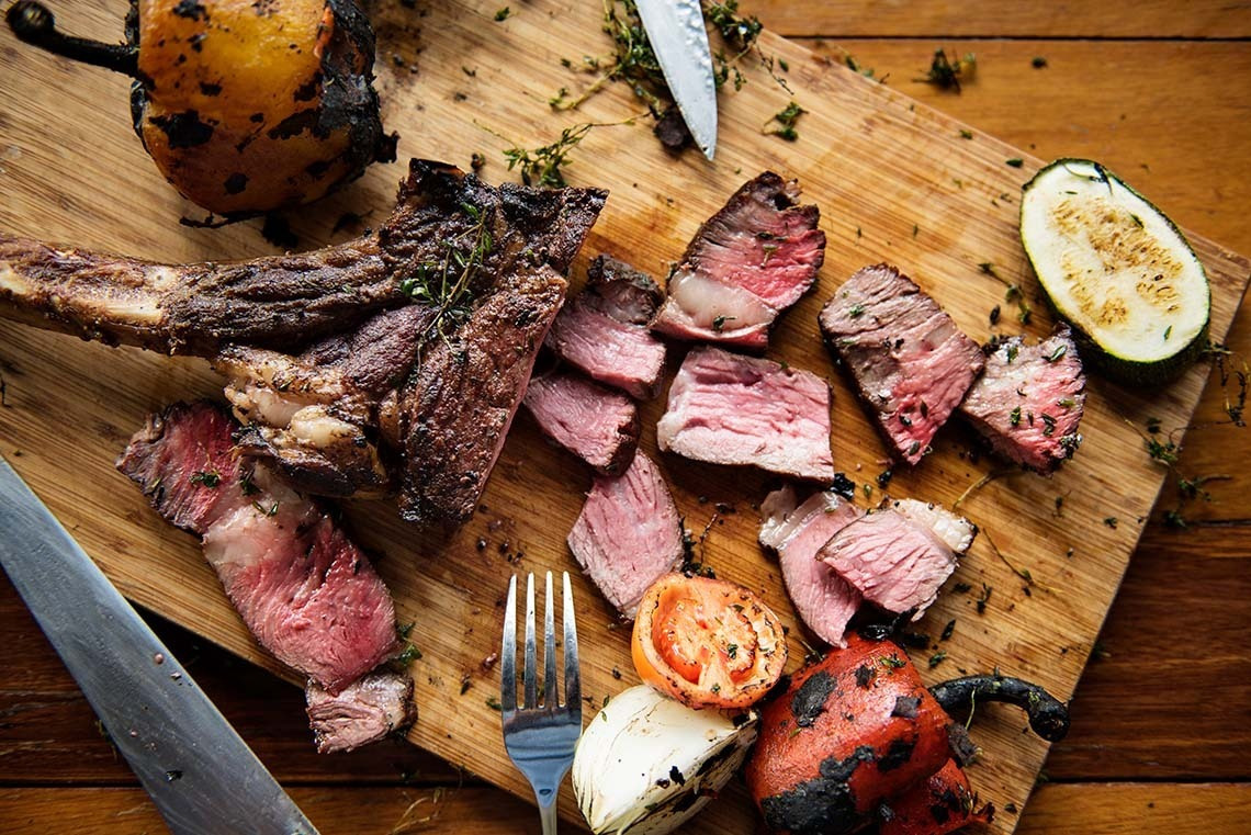 Alexandre Corporativa: Jugosa carne a la brasa y vegetales asados en tabla de madera, una experiencia gourmet.