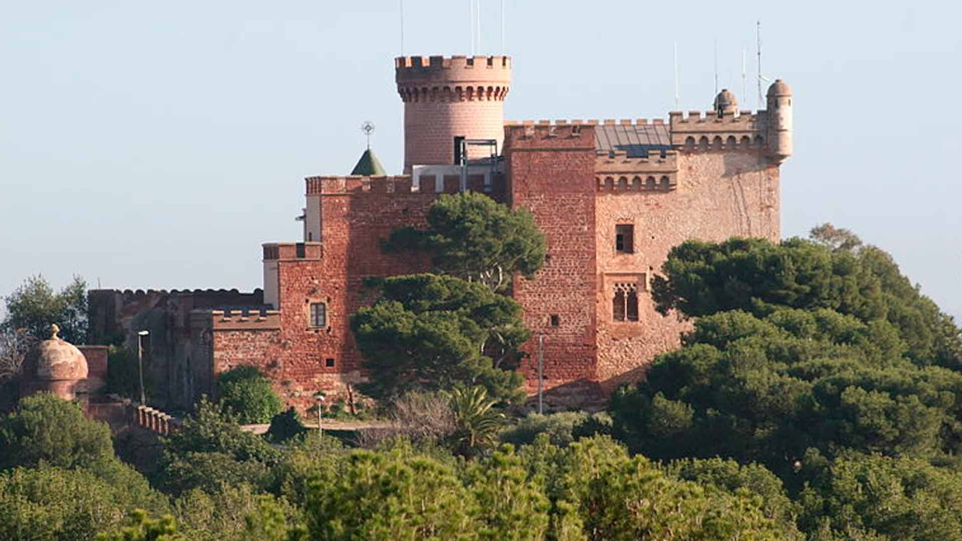 Alexandre Corporativa: Historic red-brick castle hotel surrounded by green trees.