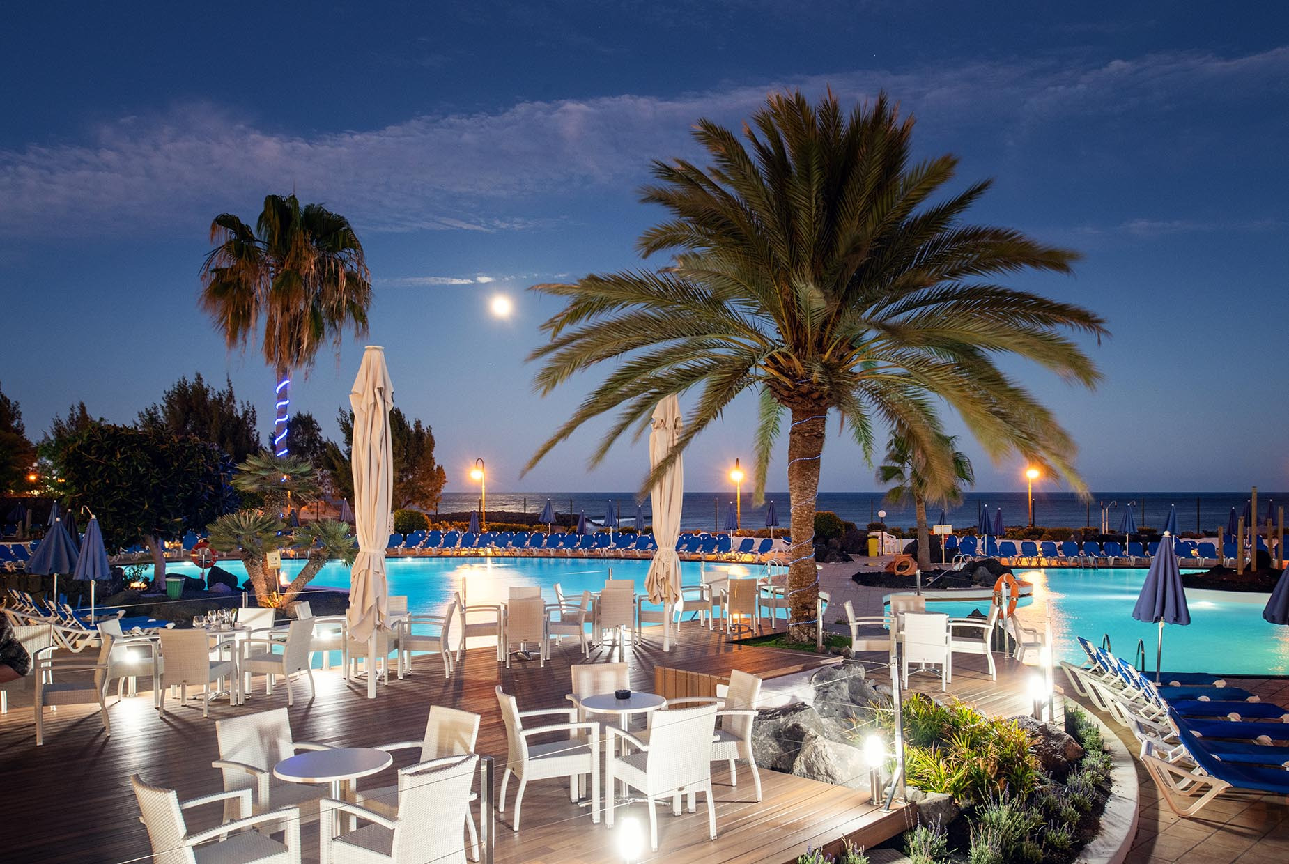 Terrasse mit Tischen und Stühlen am Pool Alexandre Teguise Playa | 4-Sterne-Hotel auf Lanzarote bei Nacht