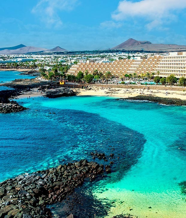 Vistas aéreas de Alexandre Corporativa: hotel junto a calas de aguas turquesas y paisajes volcánicos.