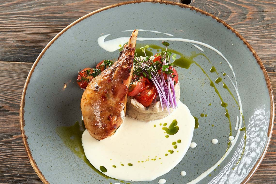 Plat gastronomique Alexandre Corporativa: cuisse de volaille rôtie, purée, tomates cerises et fines herbes.