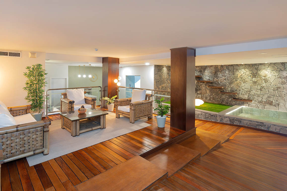 Lounge moderno Alexandre Corporativa con spa, muebles de bambú y terraza de madera.