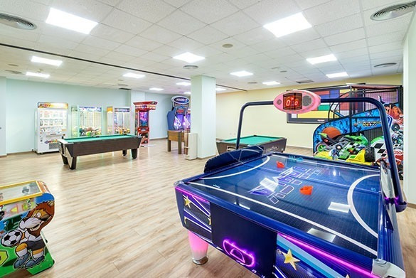 Entretenida sala de juegos Alexandre Corporativa: billares, air hockey y máquinas arcade.