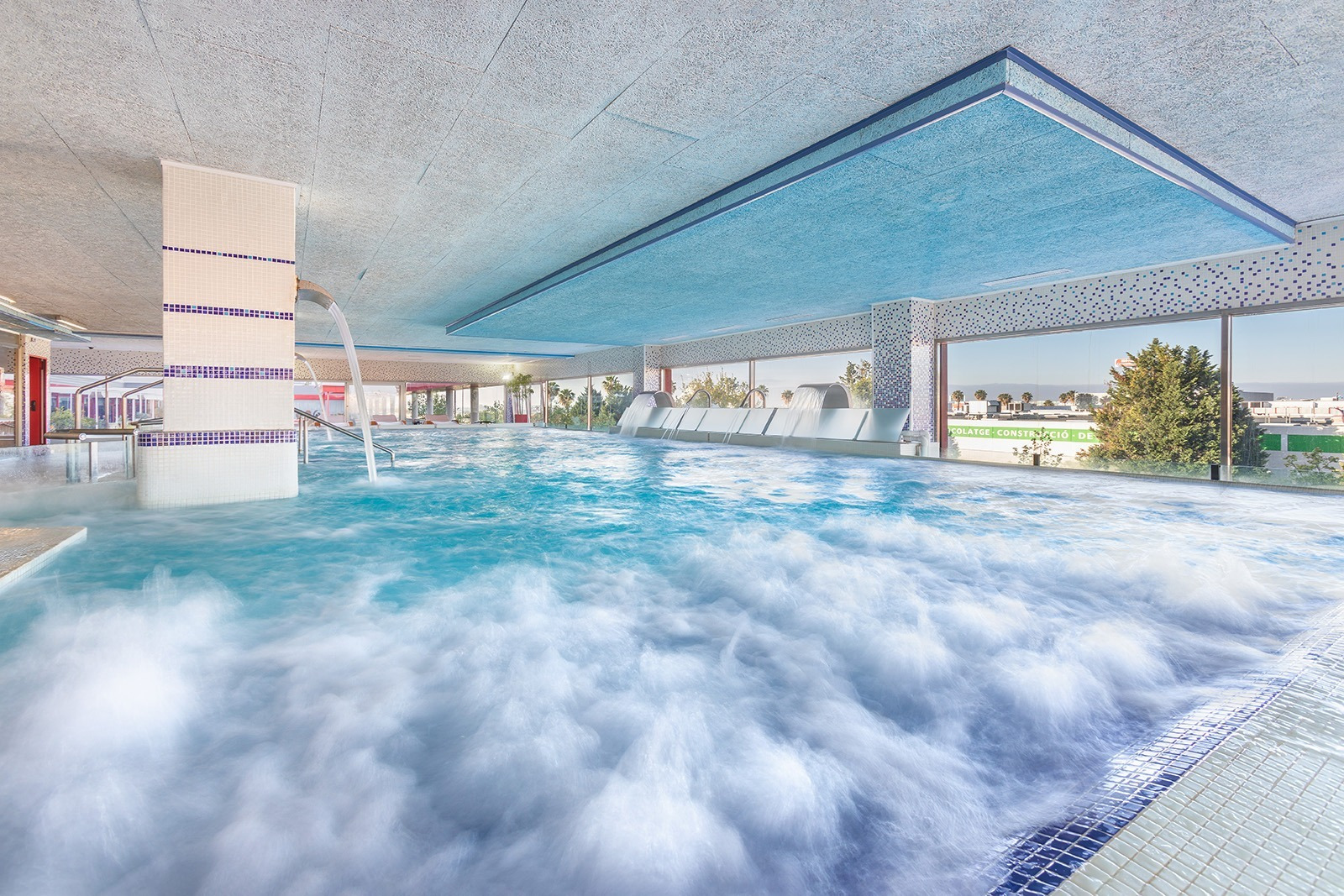 Alexandre Corporativa Hotel Innenpool mit Wasserstrahlen, Wasserfällen und großen Fenstern zum Entspannen.