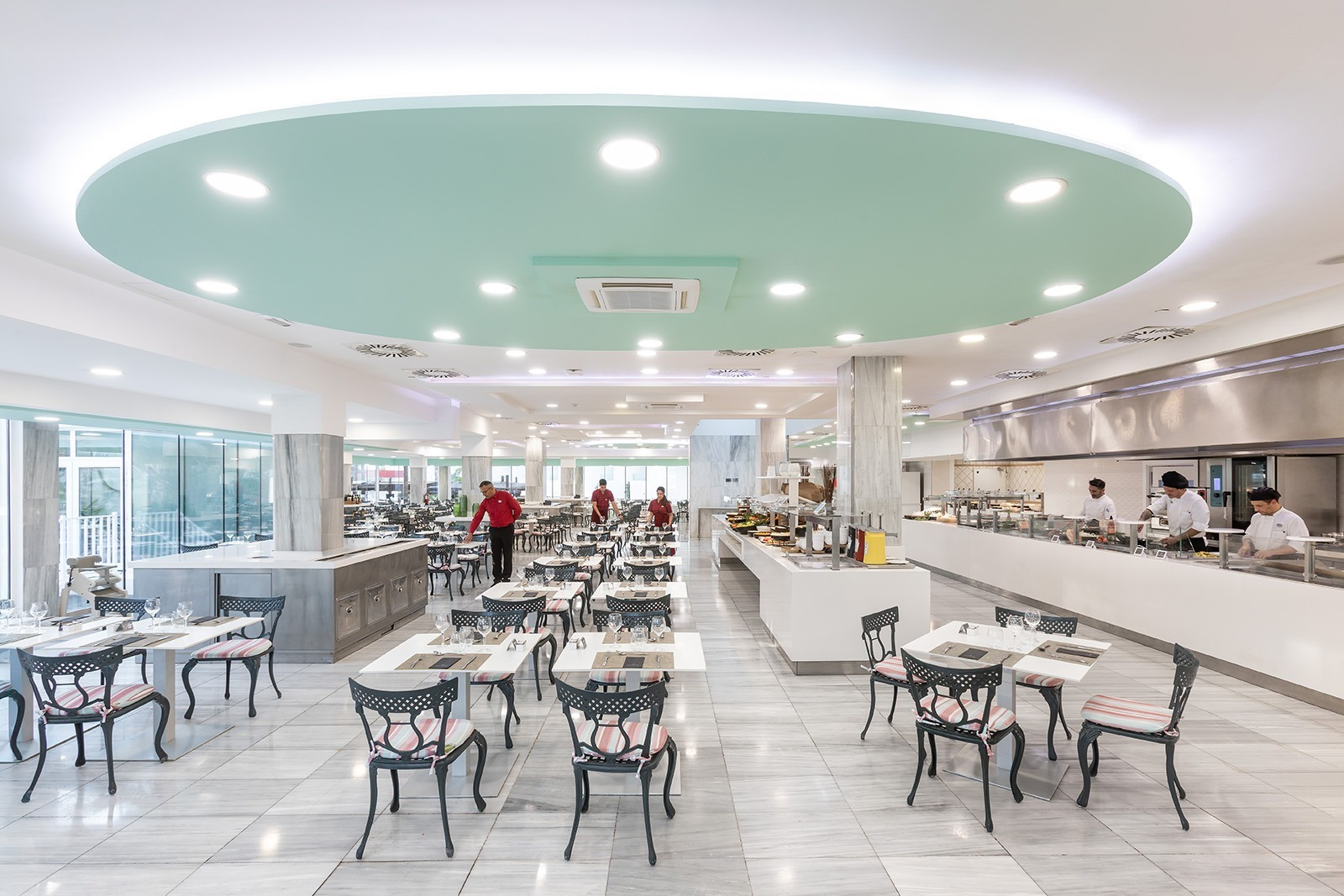 Bright Alexandre Corporativa hotel restaurant with buffet, chefs, and spacious dining tables.