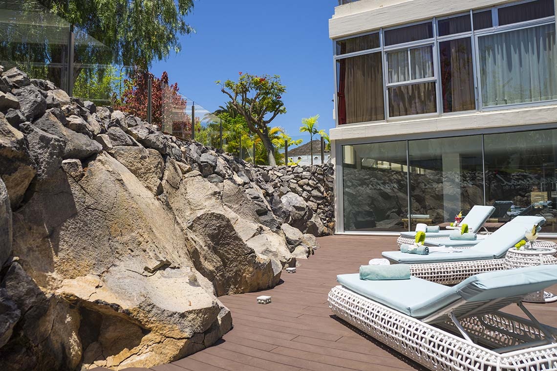 Alexandre Troya | 4-star hotel: Relaxing sun loungers on a wooden deck with rock garden, Playa de las Américas.