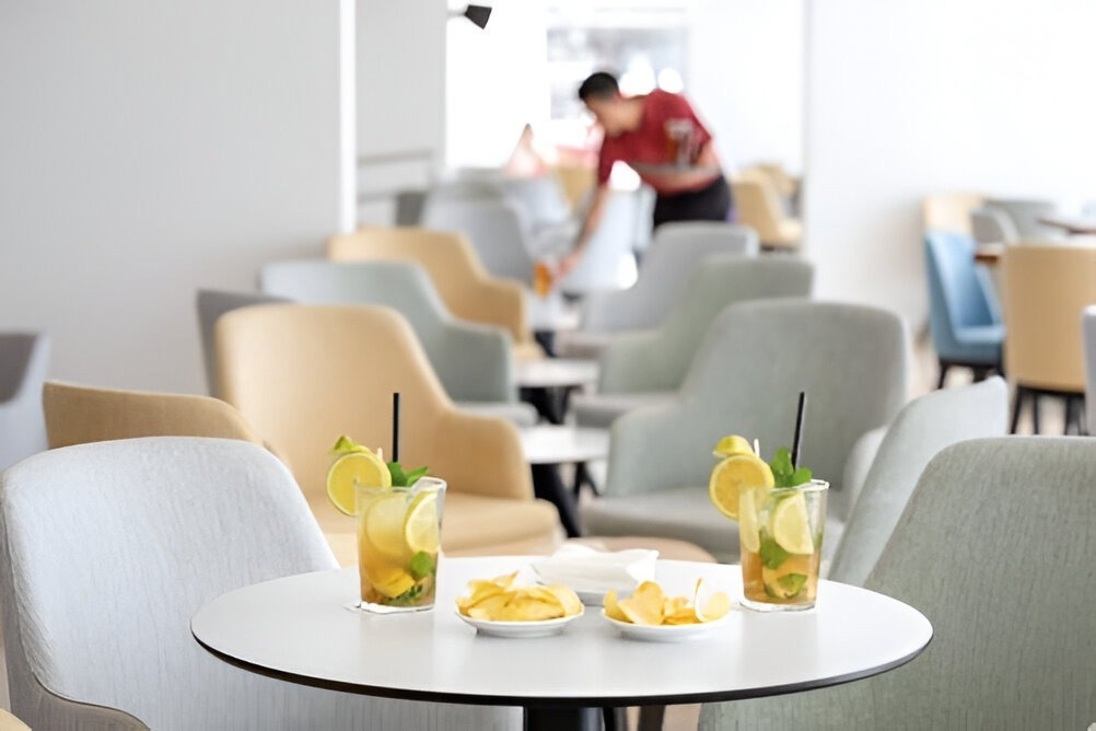 Modern hotel lounge at Alexandre Corporativa with refreshing drinks and snacks, staff attending.