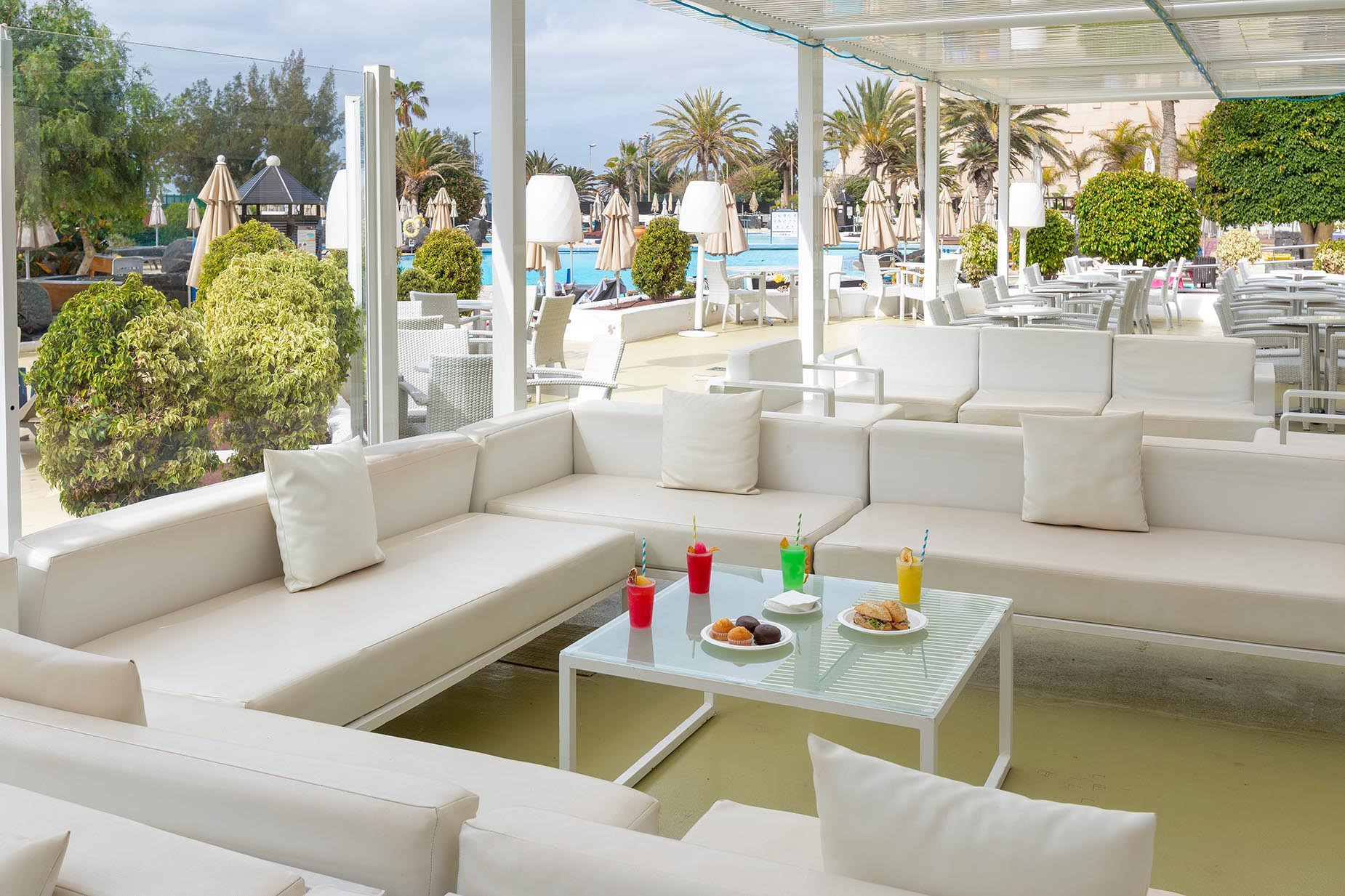 Gemütliche Lounge-Terrasse mit Sofas und Getränken Alexandre Teguise Playa | 4-Sterne-Hotel auf Lanzarote am Pool.