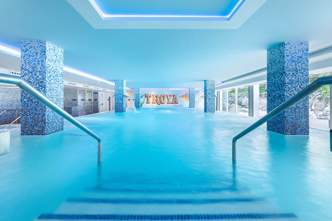Luxuriöser Innenpool im Alexandre Hotel mit Wasserrutschen und "Troya"-Schriftzug.