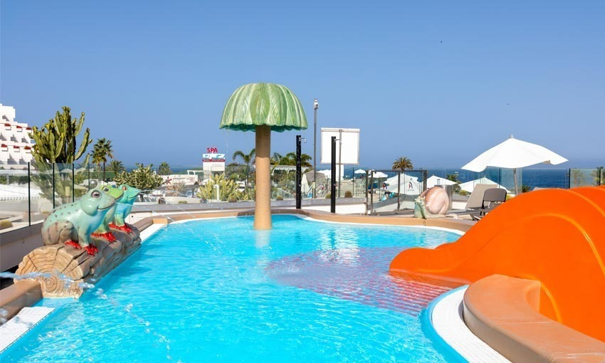 Kinderpool mit oranger Rutsche, Frosch-Skulpturen und Meerblick im Hotel Alexandre Corporativa.