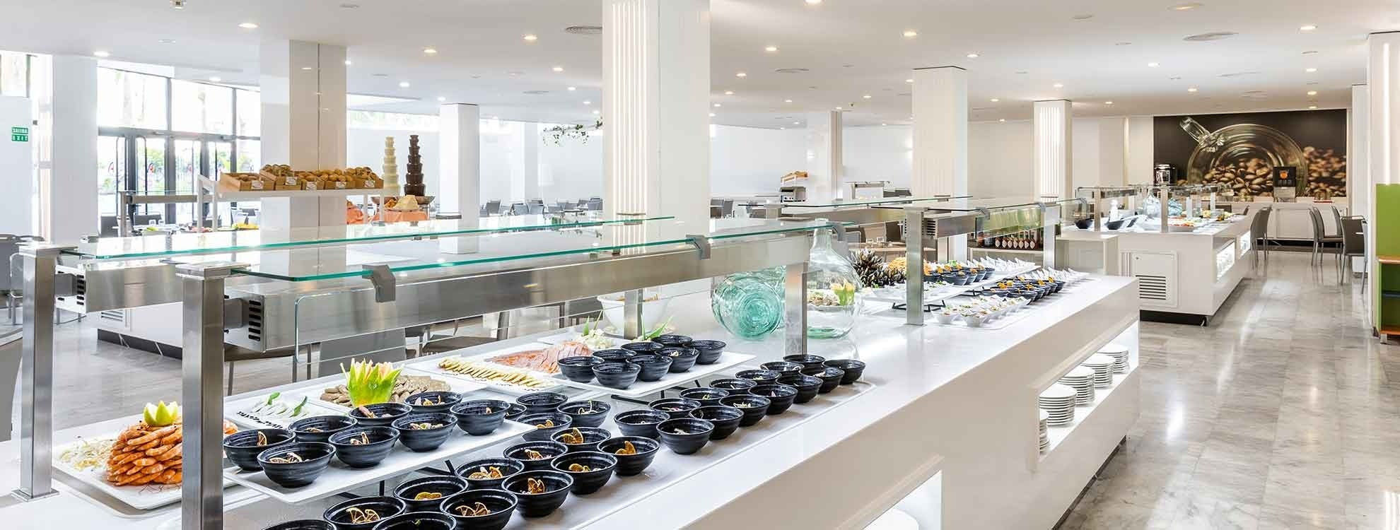 Luminoso buffet de restaurante Alexandre Corporativa con variada comida y postres.