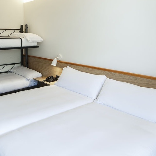 una habitación de hotel con dos camas y una litera