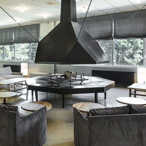 una sala de estar con sofás y mesas y una chimenea
