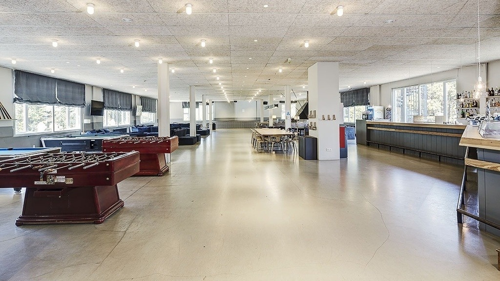 a large room with tables and chairs and a bar