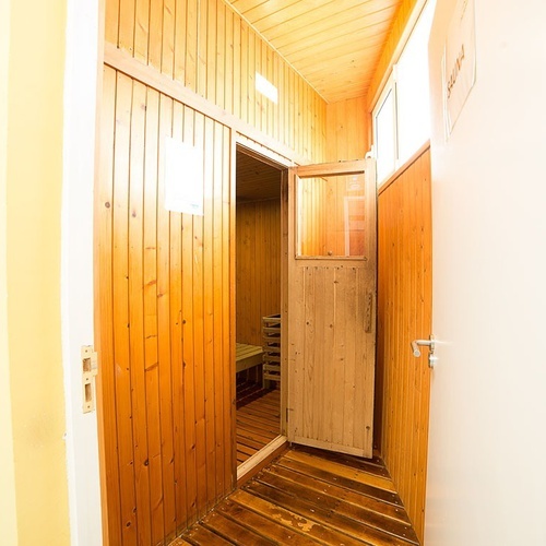 una puerta abierta que conduce a una sauna de madera