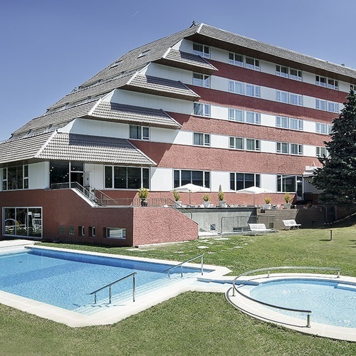 un gran edificio rojo y blanco con una piscina al frente