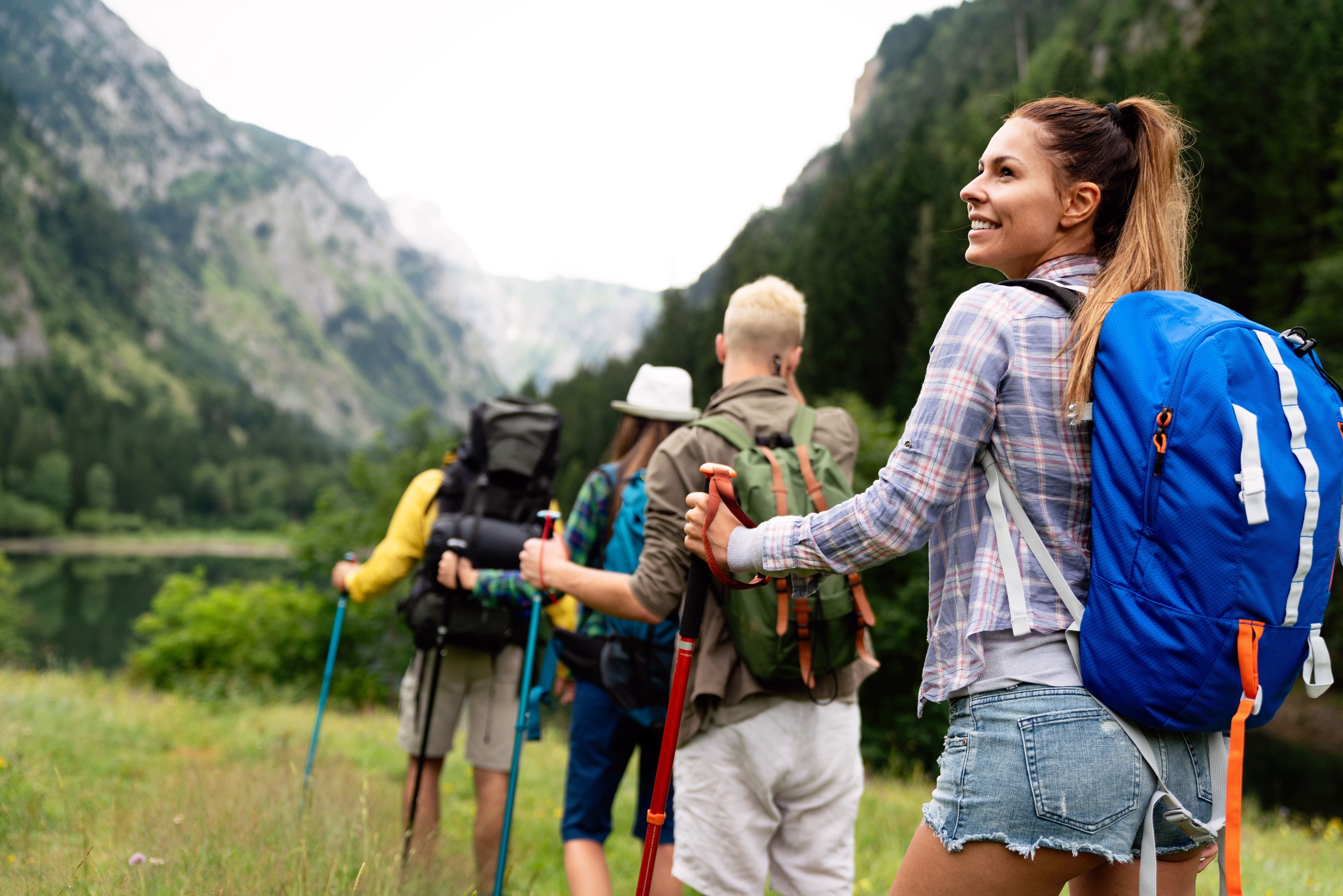 un grup de persones amb mochilas i bastones de trekking a la montagna