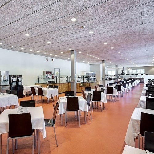 una larga fila de mesas y sillas en un restaurante