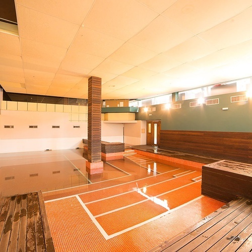 una habitación vacía con un suelo naranja y una pared de madera