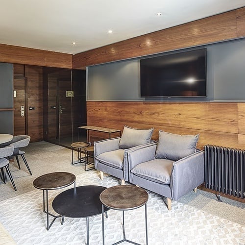 una sala de estar con una mesa y sillas y una televisión