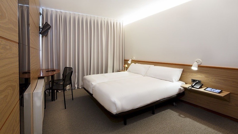 STANDARD ROOM - a hotel room with two beds and a phone on a shelf